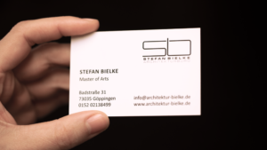 Hand hält Visitenkarte Rückseite vom Architekturbüro Bielke mit partiellem Lack Effekt