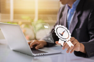 Businessman working on labtop with check mark, document symbol, and standard quality control. The concept of ISO service, international standards and quality assurance is certified.
