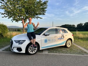 Kathrin Junker am neu beschrifteten Auto